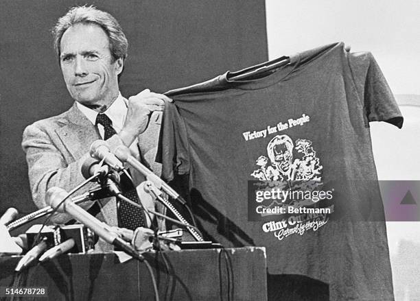 Clint Eastwood proudly holds up a t-shirt proclaiming him as the mayor of Carmel, California, during his acceptance speech on April 9, 1986.