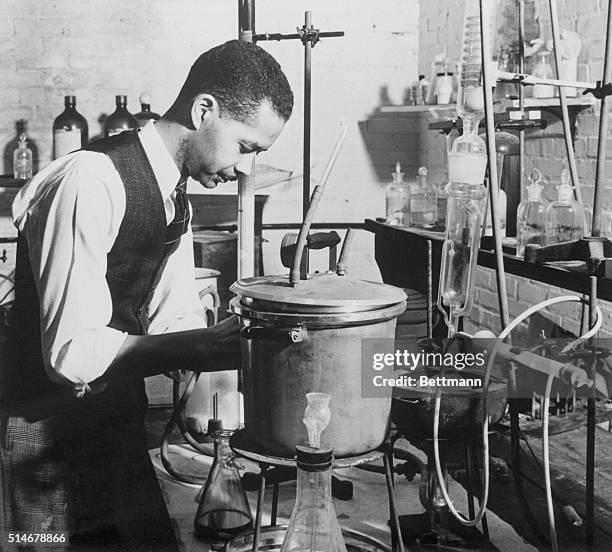Dr. Austin W. Curtis Jr., chemist and assistant to Dr. George Washington Carver, conducts an experiment in a laboratory of the Tuskegee Institute in...