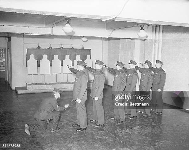 New York police academy recruits practice target shooting with revolving dummy targets. Sergeant Joe Evans pulls a string to turn the dummies.