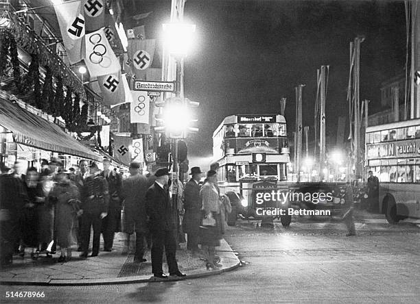 The intersection of Unter Den Linden and Freidrichstrasse in Berlin during the 1936 Olympic Games, with both Nazi and Olympic flags hanging from...