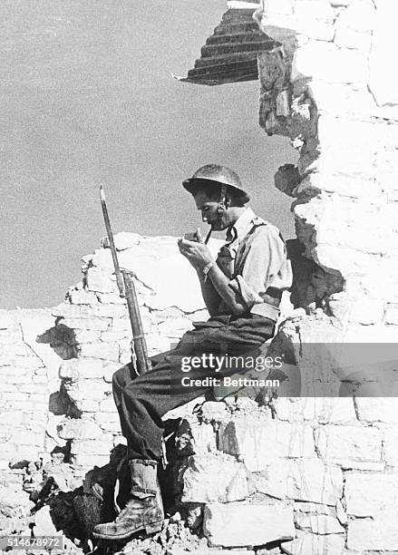 Mersa Mutruh: A British Tommy, who has been searching the ruins of Mersa Matruh where anything from a Nazi tank to a string og supply trucks might be...