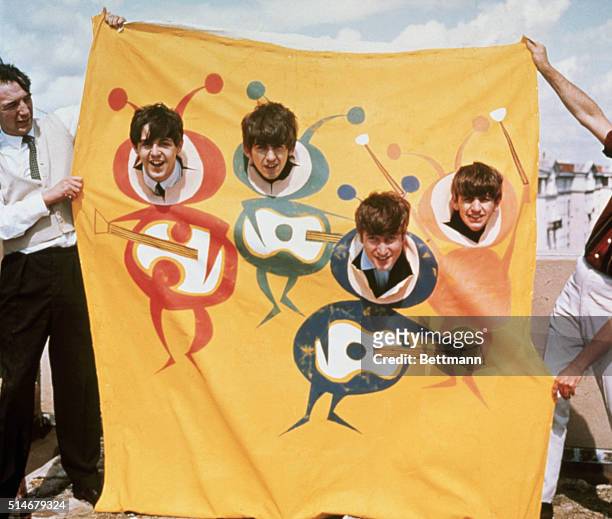 The Beatles poke smiling faces out of a banner drawn with beatle bodies holding guitars in the early part of their band's career.