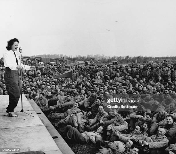 GIs flock around an improvised platform to witness the first USO camp show in France, July 26, 1944. CREDIT BETTMANN/UPI