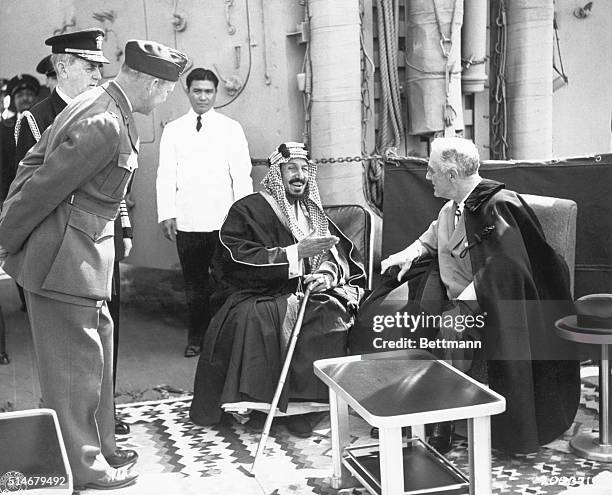 King Ibn Sa'ud of Saudi Arabia converses with President Franklin Delano Roosevelt aboard the USS Quincy at the Great Bitter Lake in the Suez Canal,...