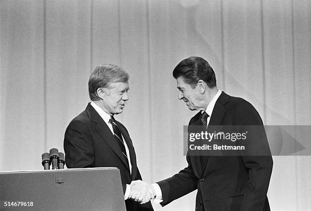 President Jimmy Carter and his Republican challenger, Ronald Reagan, shake hands as they greet one another before their debate on the stage of the...