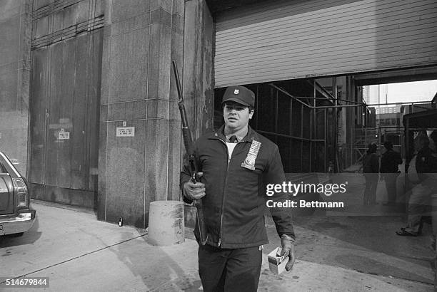 New York: A "SWAT" officer with a shotgun stands guard 12/11 at Manhattan Criminal Court where Mark Chapman made an unexpected appearance in a bullet...