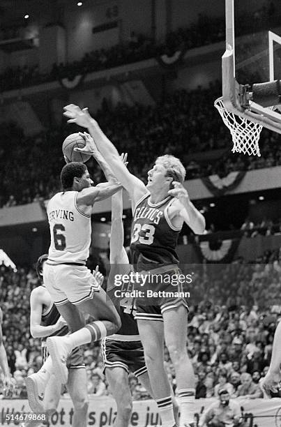 Philadelphia 76ers forward Julius Erving attempts to take a shot over the outstretched arms of Larry Bird of the Boston Celtics in a NBA basketball...