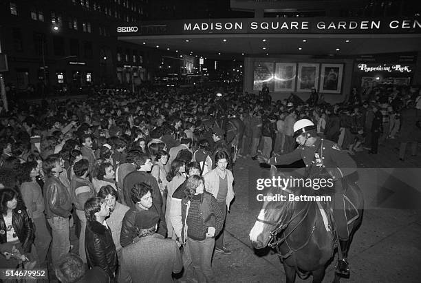 Enthusiasts of the performance group The Rolling Stones listen to advice from a mounted police officer, before attending a "rock and roll" concert at...