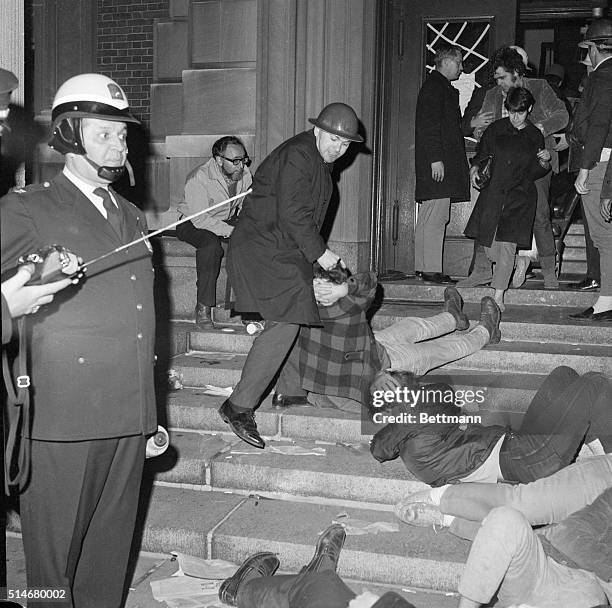 New York:Two policewoman lead the way as they are assisted in forcibly removing a Columbia University Co-ed from a besieged campus building Apr. 30....