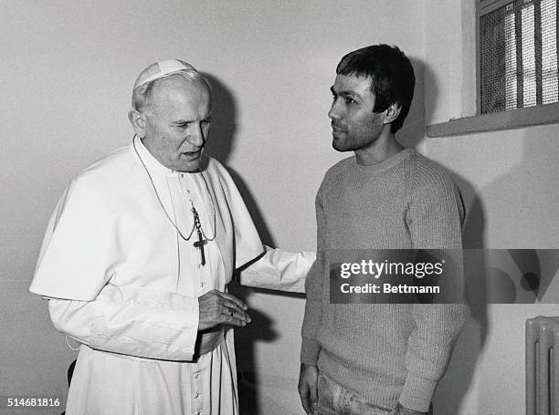 Pope John Paul II speaks with Mehmet Ali Agca, the man who tried to kill him. | Location: Rebibbia Jail, Rome, Italy.