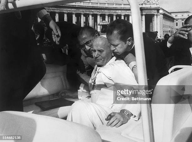 Vatican City: Blood on his hands, Pope John Paul II is assisted by aides moments after he was shot while riding in his open car in St. Peter's Square...