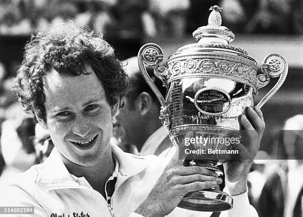 London, England: America's John McEnroe holds the winners trophy 7/3 after defeating New Zealand's Chris Lewis in the Men's Singles Final at...
