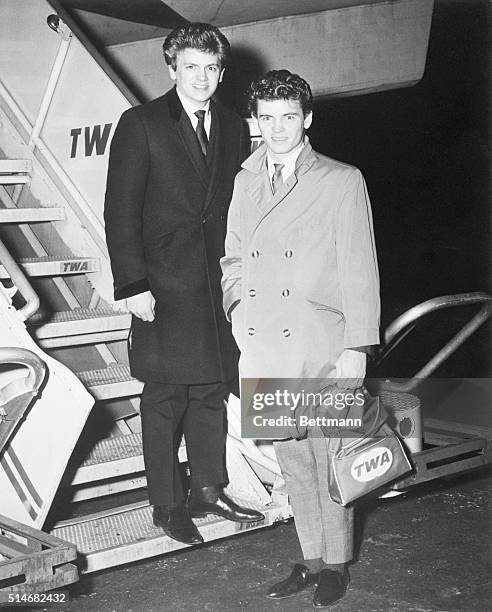 Portrait of the Everly Brothers, Phil and Don, about to board a plane to London.