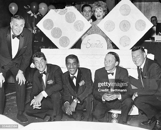 Dean Martin, Sammy Davis Jr., Danny Thomas, Lucille Ball, Frank Sinatra stand around a cake for the eleventh anniversary of the Sands Hotel in Las...