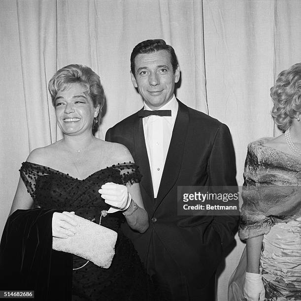 Simone Signoret, with husband Yves Montand, arriving at the Academy Awards before winning the Academy Award for Best Actress, for her work in Room At...