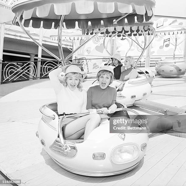 Andrea Peters and Sasha Alexander help test out a ride for an amusement park that will soon open in Palisades Park, New Jersey. March 24, 1964.