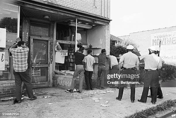 Police officers search men accused of looting during race riots in Detroit, Michigan.