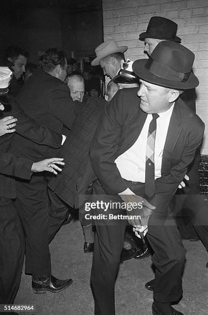 Dallas police struggle with Jack Ruby, after the nightclub owner shot alleged assassin Lee Harvey Oswald. The officer in the foreground holds the gun...