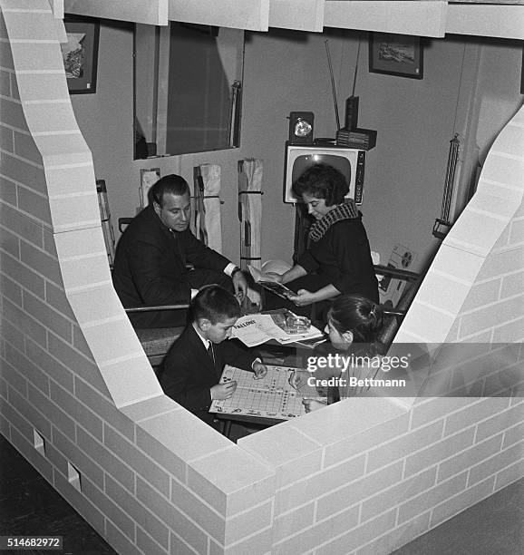 Mr. And Mrs. Nathaniel Schaffaud and their children, Eric and Diane, settle into a deluxe fallout shelter on display at Civil Defense headquarters in...