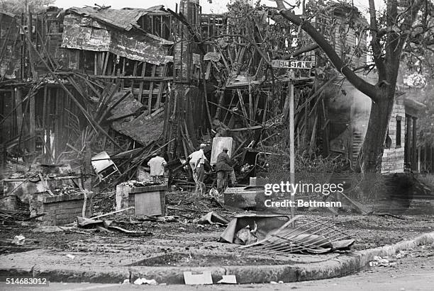 Men search through the ruins of building burned during a fire in Birmingham, Alabama sparked by racial tension.
