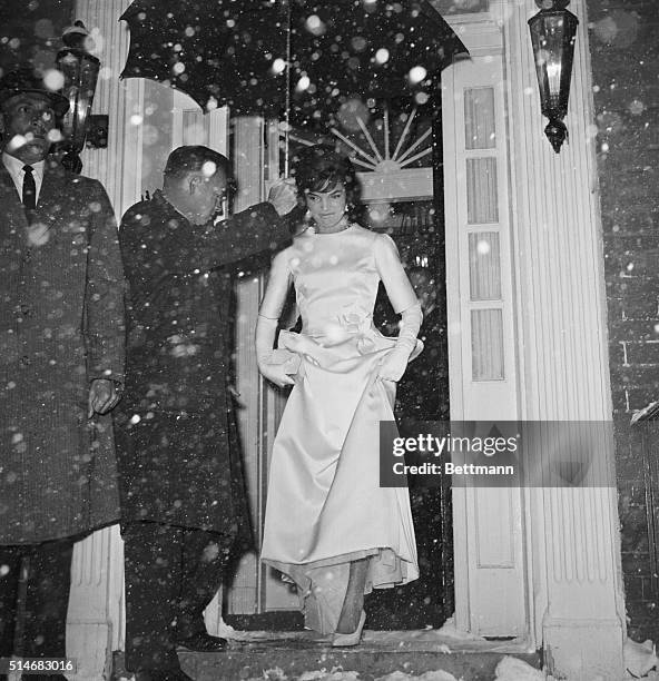 Jackie Kennedy, wife of President-elect John F. Kennedy steps into the snowy nigh from her Georgetown home. She is headed for the Inauguration...