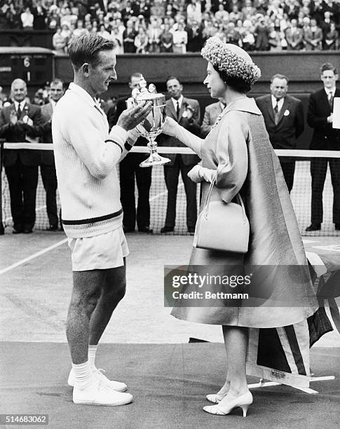 Queen Elizabeth of England presents the 1962 Wimbledon trophy to Rod Laver of Australia.