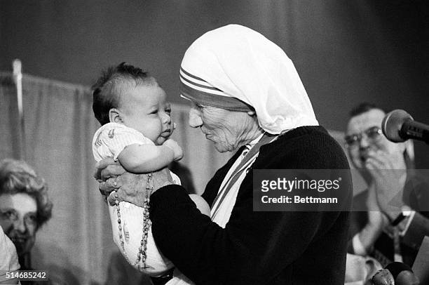 Washington: Mother Teresa holds up an unidentified baby for a close look while attending the National Right to Life convention 6/21. Mother Teresa,...