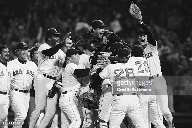 Players on the Boston Red Sox celebrate their American League championship victory, including Don Baylor , Bruce Hurst , Dave Stapleton , and playoff...