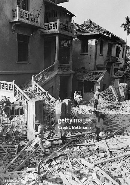 North Vietnamese rescue workers search the debris and rubble around the Cuban Embassy in Hanoi after a bombing by United States.