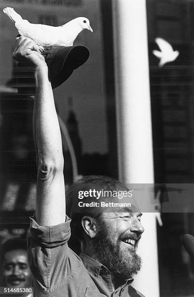 Folk singer Pete Seeger holds up a dove on his hat at a Times Square anti-Vietnam War rally.