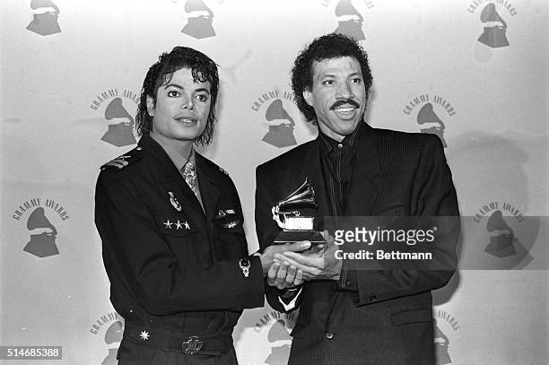Singer-songwriters Michael Jackson and Lionel Ritchie hold their Grammy Award for "We Are the World".