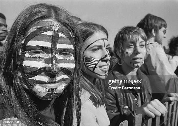 Three young women, their faces painted with American flags and peace signs, take part in a large anti-war demonstration on Boston Common, which drew...