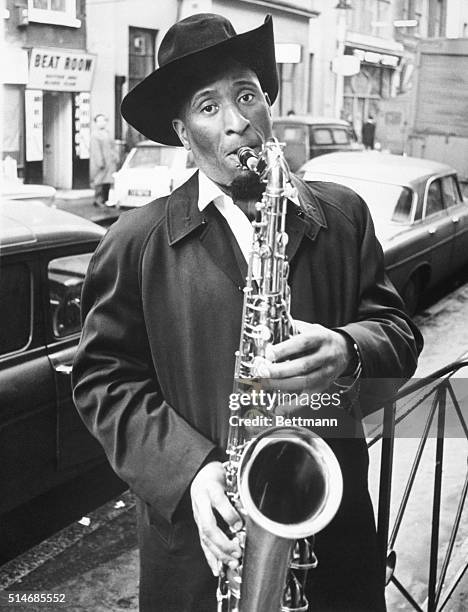 Tenor saxophonist Sonny Rollins plays on a street in London's Soho district before his British debut.