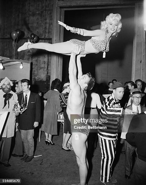 Mickey Hargitay holds his wife, pin-up star Jayne Mansfield high above him, on October 30, 1956. They are dressed in leopard print bathing suits for...