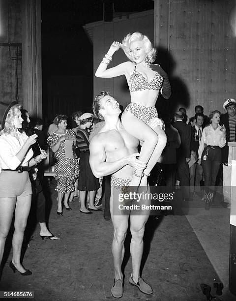 Pin-up star Jayne Mansfield sits on the shoulders of her husband, Mickey Hargitay, on October 30, 1956. They are dressed in leopard print bathing...