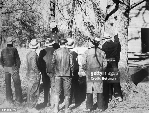 Slayden, MS: Spectaters view the body of Ab Young colored boy after he had been lynched by a mob of 50 men, at Slayden, MS, March 12. Young was...