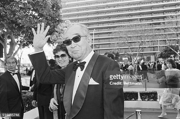 Director Akira Kurosawa waves as he arrives at the Oscar ceremony on March 24, 1986. Kurosawa was nominated as Best Director for his film Ran.