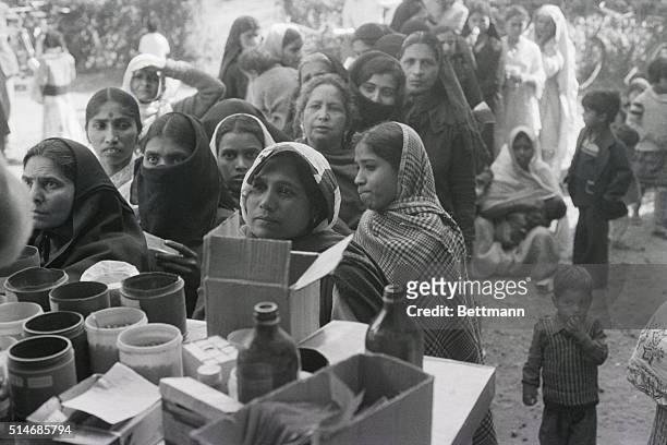 Crowd of women and children, poisoned by the Bhopal pesticide leak, line up for medication at a government clinic.