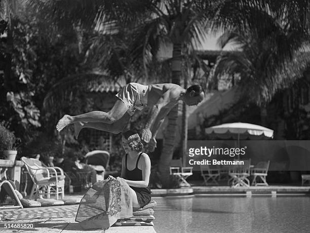 Actor Douglas Fairbanks Sr. Dives over wife, Sylvia Ashley, into a pool in Palm Beach where they are vacationing.