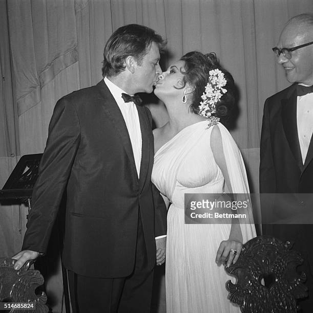 New York: Actor Richard Burton kisses his beautiful actress-wife Elizabeth Taylor following their successful benefit performance of prose and poetry...