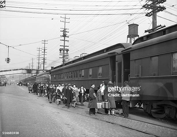 Crowd of onlookers watch from a bridge as a mass evacuation takes place of Japanese Americans from Bainbridge Island, Seattle, Washington, 30th March...