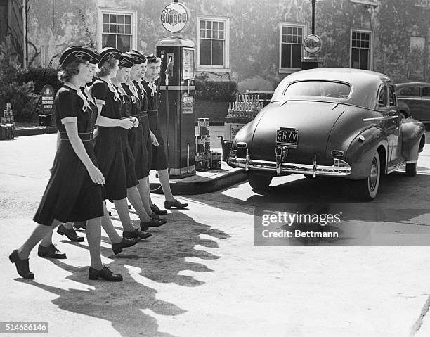 Chestnut Hill, Pennsylvania: Wearing smart uniforms, the first group of girl gasoline station attendants hired by the Sun Oil Company to take the...