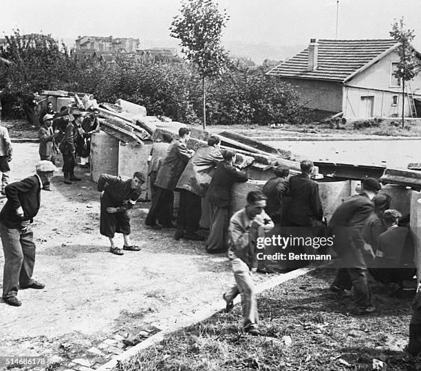 Members of the French Forces of the Interior, a group organized from the factions of the French Resistance, defend a Paris street from behind a...