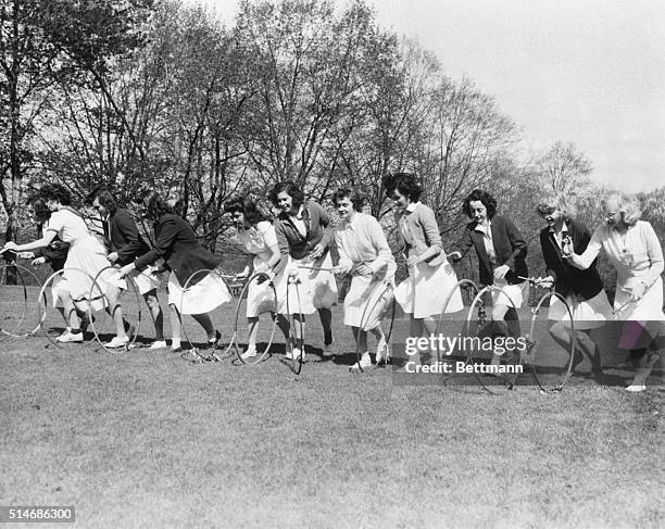 Bryn Mawr, PA: Wearing the traditional white skirts, Bryn Mawr College students roll beribboned hoops across the campus as part of the schools May...