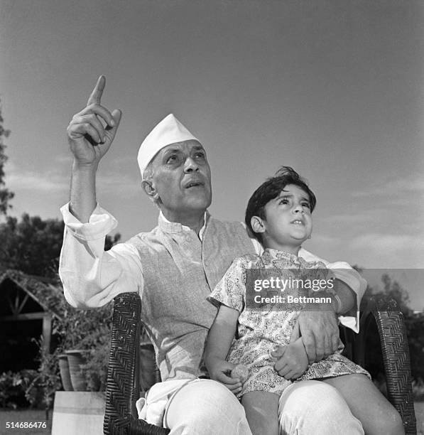 Prime Minister Pandit Jawaharlal Nehru tells his grandson Rajiva Gandhi a story in the family garden.