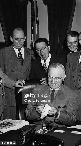Washington, DC: President Truman wipes the pen he used when he signed the school lunch bill June 4, which provides for Federal Assistance to state...