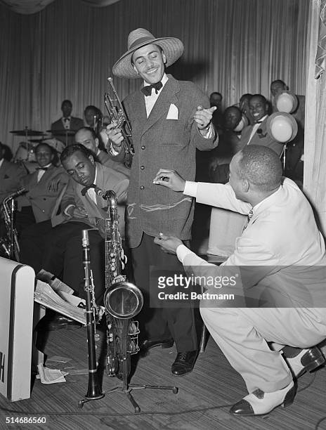 Jazz Band Leader, Lionel Hampton, draws an alteration markings on the jacket of his trumpeter. The jacket will be altered into a Zoot Suit, which...