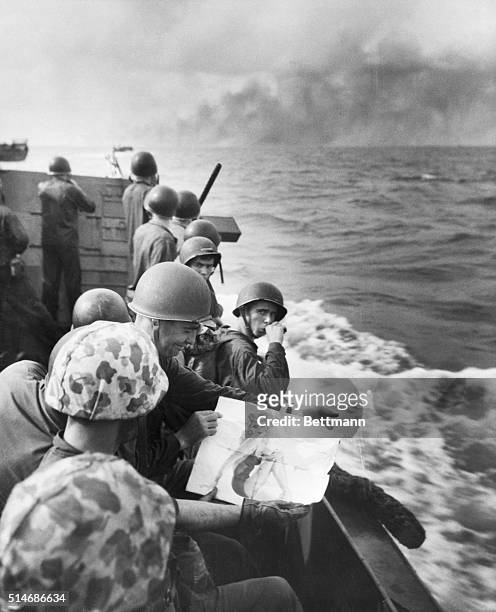 As a landing barge approaches the Jap-held island of Tarawa, a Marine takes a last look at his picture of a pin-up girl. Tarawa burns in the...