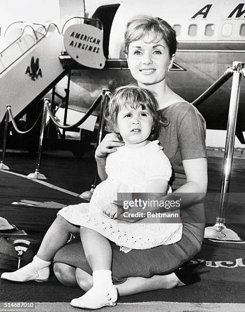 New York, NY: Actress Debbie Reynolds and daughter Carrie, 2 1/2, have contrasting expressions prior to boarding an American Airlines jet at...