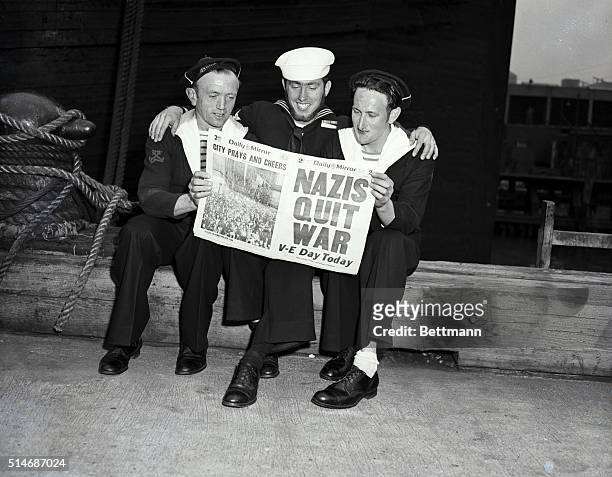 New York, NY: Three men holding up a copy of the Daily Mirror with headline "Nazis Quit War". V-E Day.